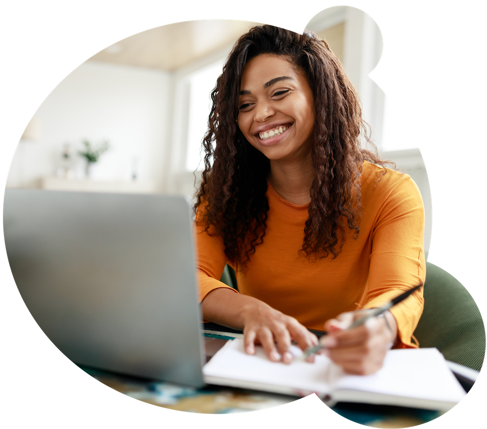 woman-sitting-at-desk-using-computer-and-writing-2022-12-16-08-06-31-utc